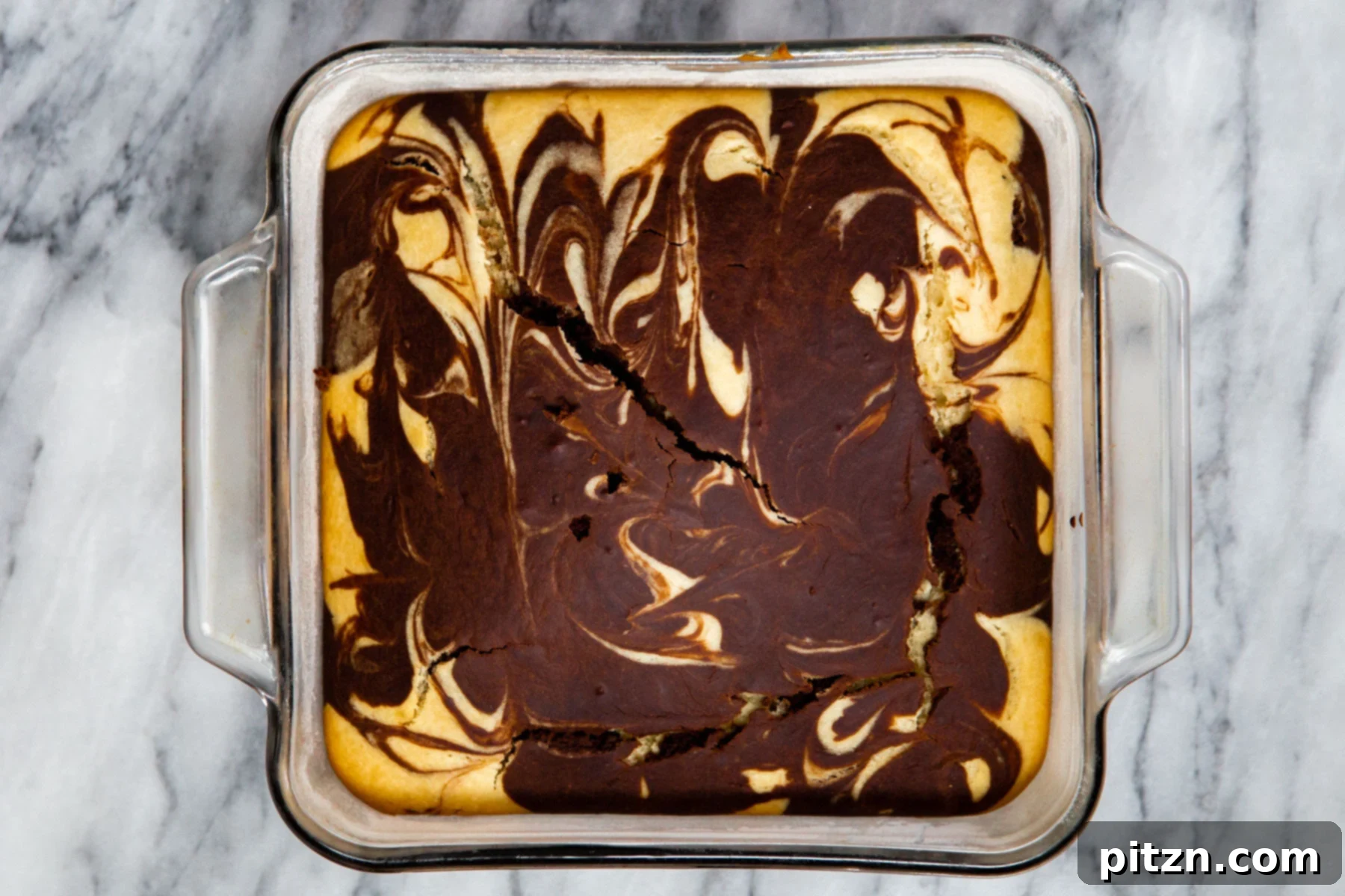 Decadent Mocha Swirl Cake 18 A freshly baked, golden-brown vegan marble cake in a square pan, cooling on a wire rack.