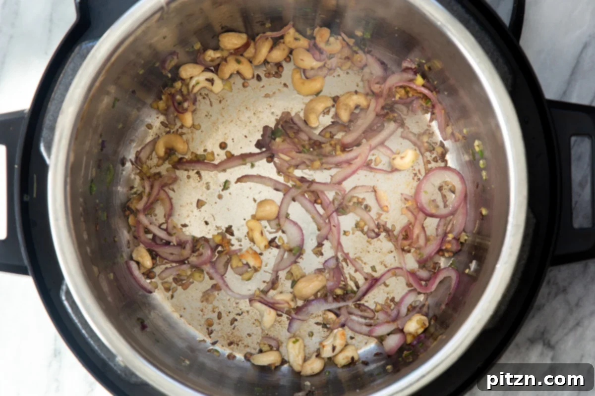 The fragrant sautéed spice base for the samosa filling, ready for potatoes, highlighted within the Instant Pot.