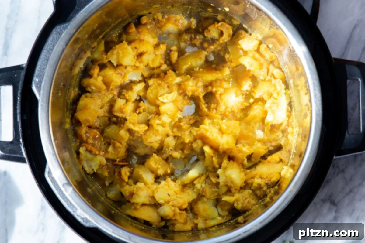 Mashed potatoes in an Instant Pot, part of the process of preparing the rich and flavorful samosa filling.