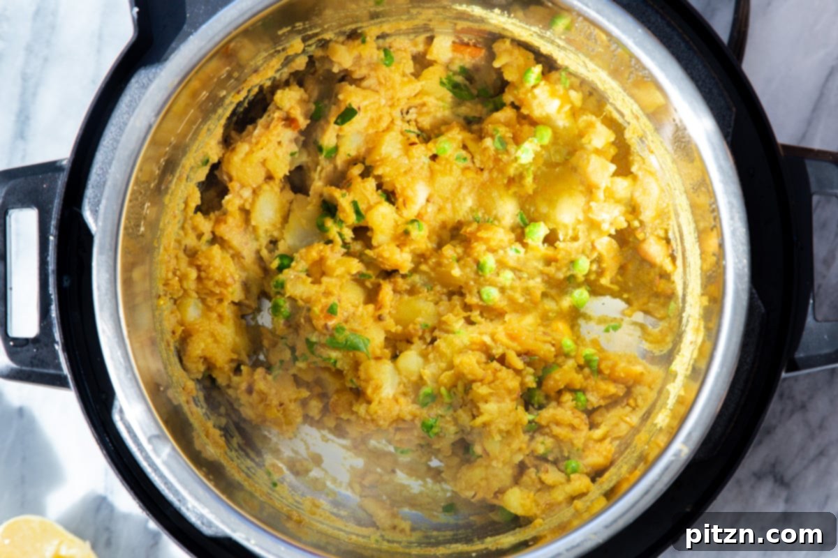 The fully prepared and fragrant potato samosa filling resting in an Instant Pot, showcasing its rich texture and readiness for pie assembly.