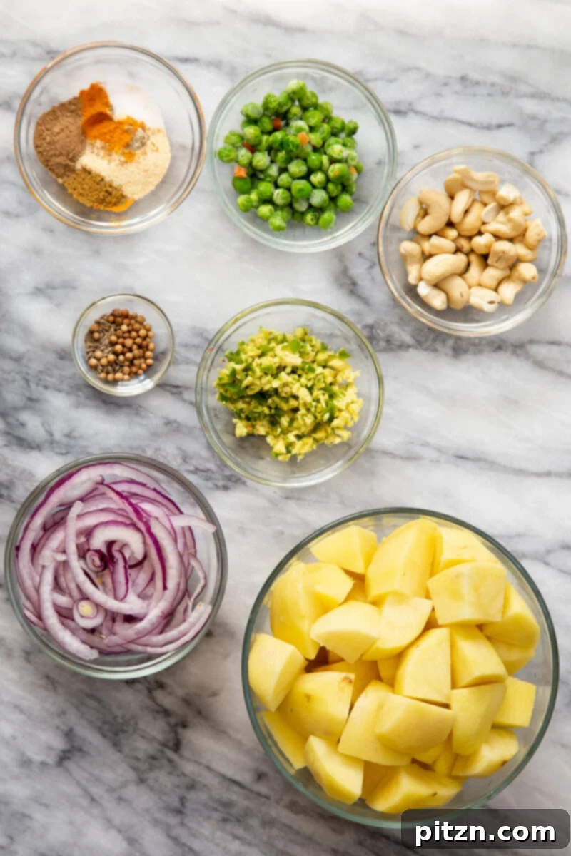 A selection of fresh ingredients, including potatoes, spices, herbs, and cashews, laid out for making the flavorful vegan samosa pie filling.