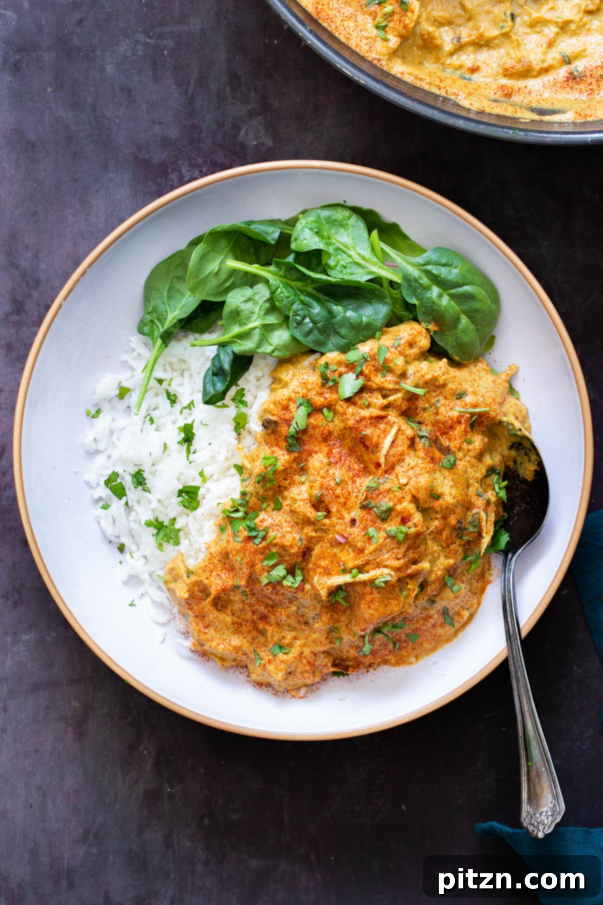 a serving of vegan shahi chicken korma with jackfruit served with rice and spinach