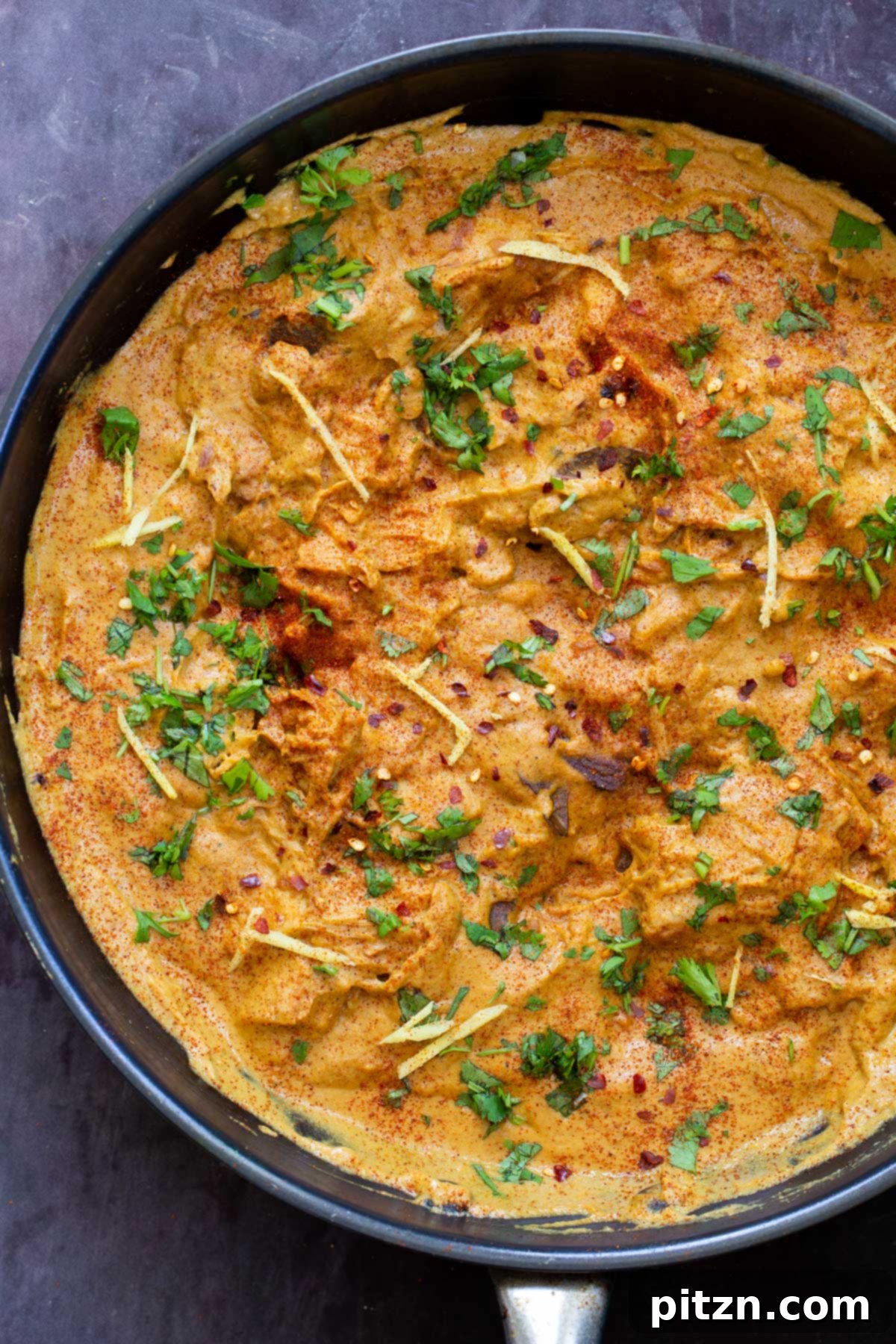 a black skillet with vegan chicken korma with jackfruit 