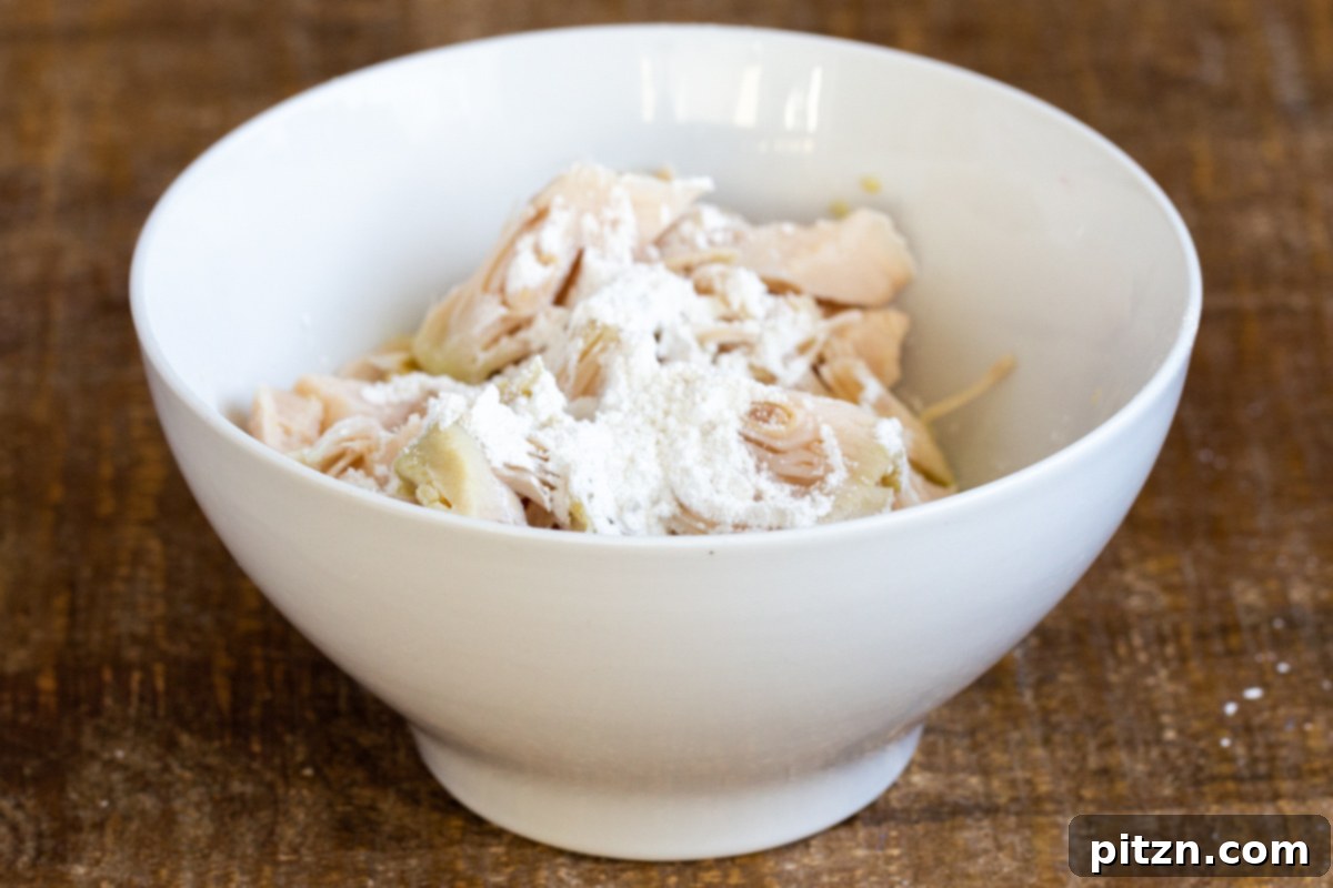 jackfruit chunks in a small white bowl coated with cornstarch 