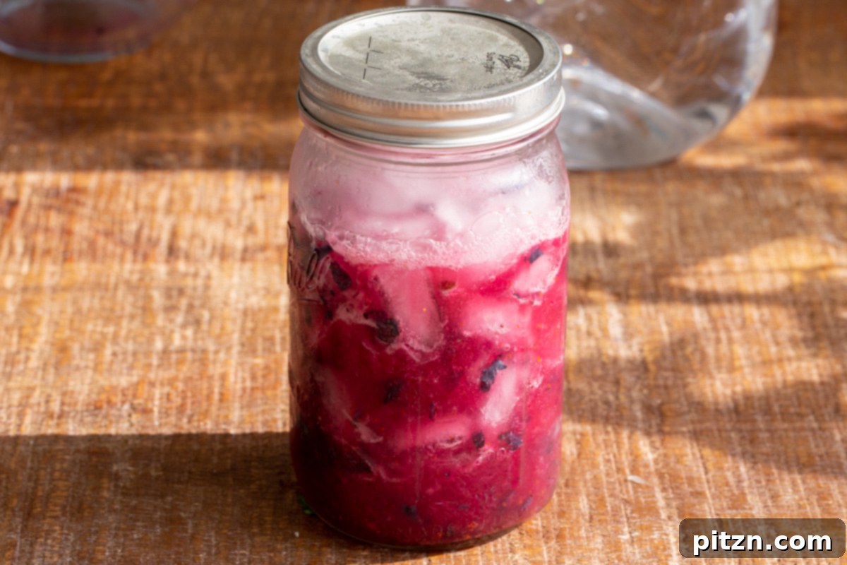 Fresh blueberry lemonade served in a mason jar with the lid on, showing its readiness to be enjoyed.