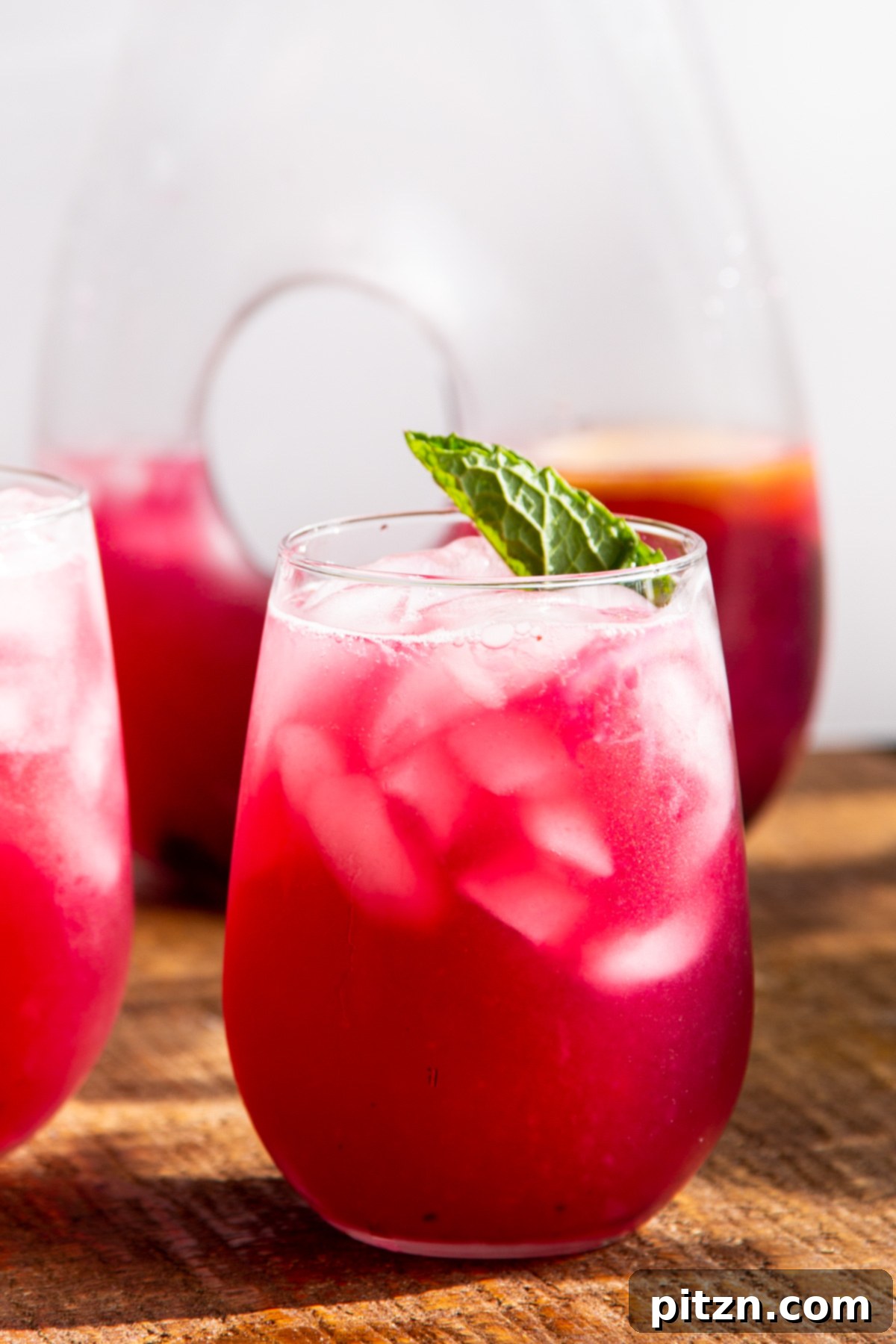 A beautifully presented glass of homemade blueberry lemonade, garnished with a single mint leaf, ready to be enjoyed.