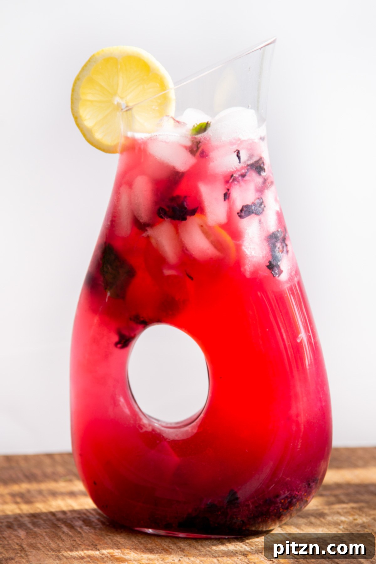 A glass jar filled with homemade fresh blueberry lemonade, ice cubes, and mint leaves, ready to be served.