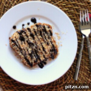 A slice of vegan Samoa French toast on a white plate, drizzled with chocolate and garnished with toasted coconut.