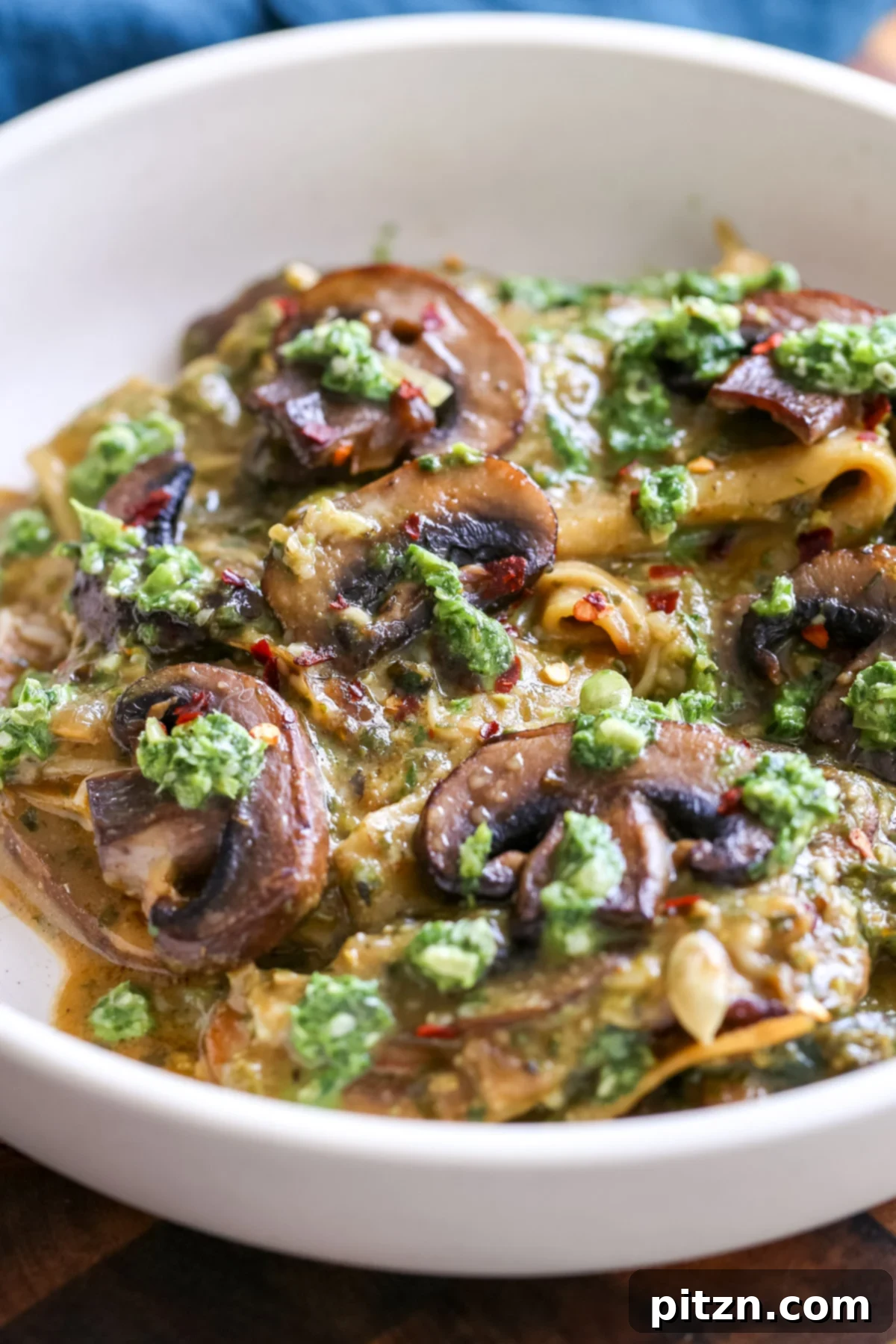 A vibrant bowl of Pesto Skillet Lasagna with mushrooms, basil pesto, and vegan cheese, ready to be enjoyed.