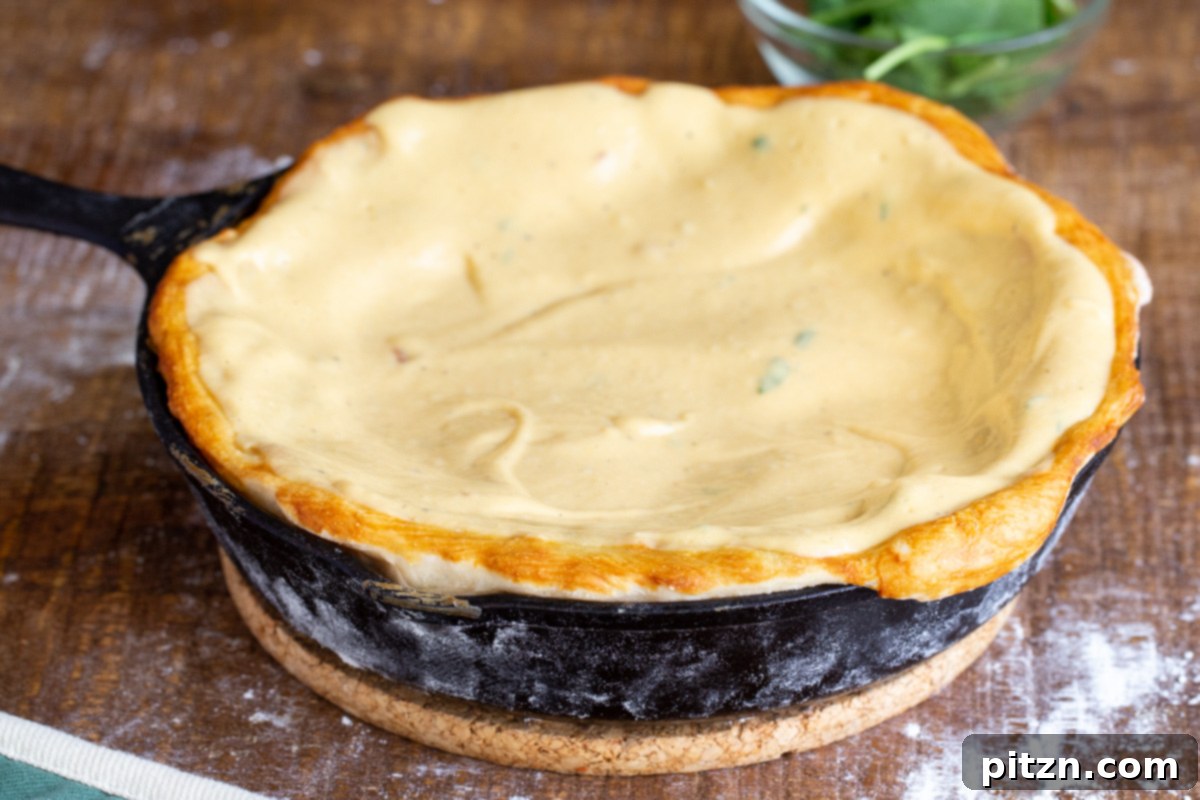 Deep Dish Pizza with a Pretzel Twist 14 Rich vegan cheese sauce being spooned into the golden, prebaked pretzel pizza crust nestled in a cast iron skillet.