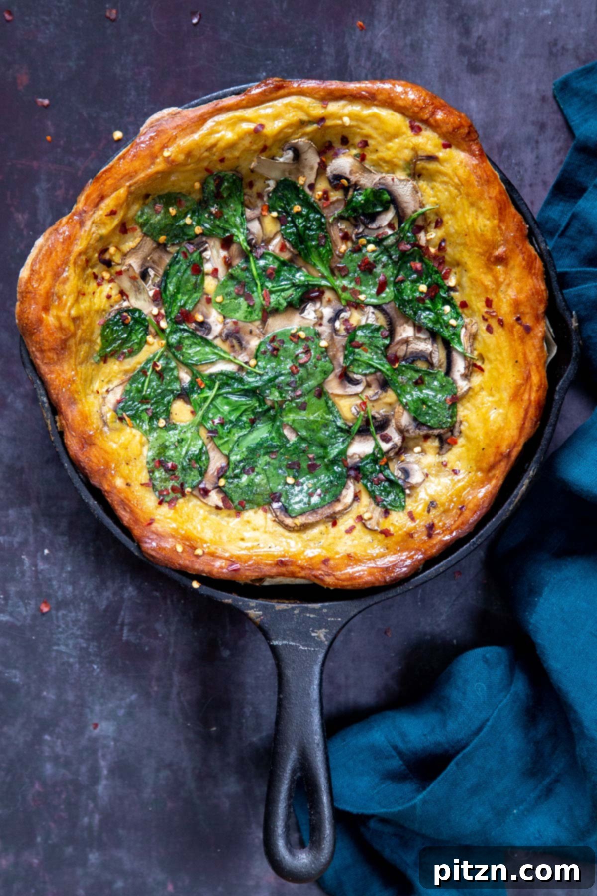 Deep Dish Pizza with a Pretzel Twist 7 A glorious vegan deep dish pizza in a black skillet, generously topped with fresh spinach and savory mushrooms, ready to be enjoyed.