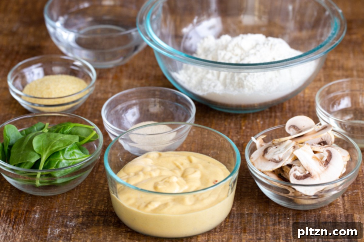 Deep Dish Pizza with a Pretzel Twist 8 A collection of fresh ingredients laid out, including sliced mushrooms, vibrant spinach, a bowl of vegan cheese sauce, and various flours, ready for making vegan deep dish pretzel crust pizza.