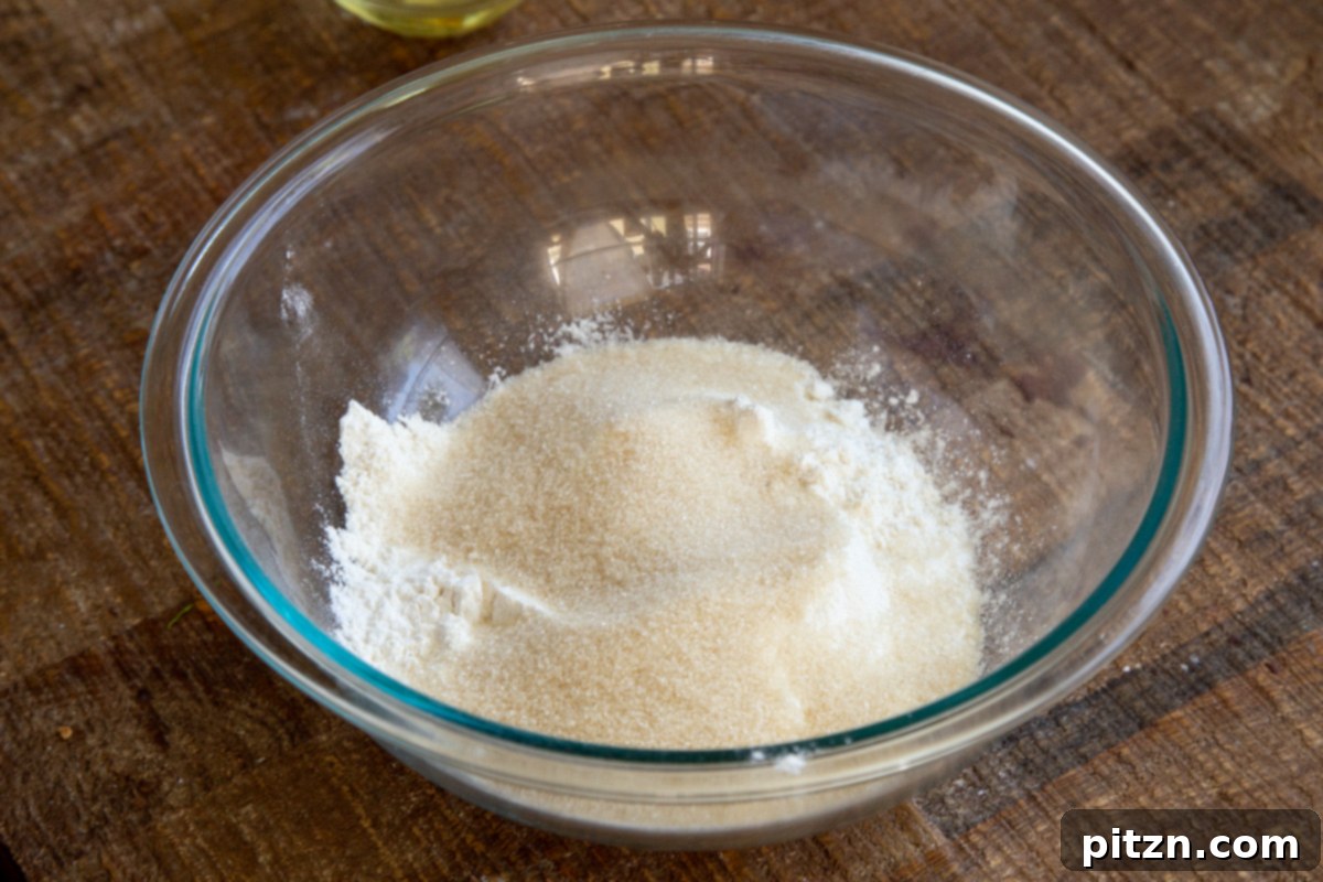 Plant-Based Tiramisu Tray Bake 8 All the dry ingredients for the vegan tiramisu sheet cake neatly arranged in a clear glass bowl, ready for mixing.