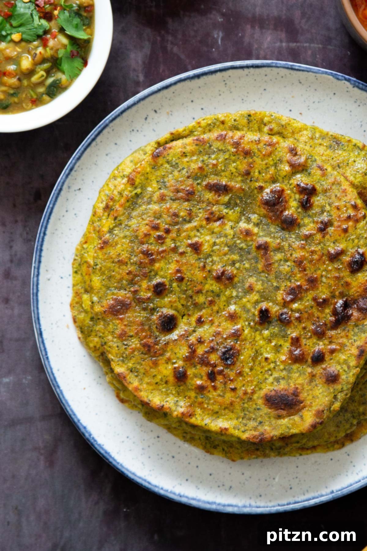 Aromatic Masala Paratha: Easy Yeast-Free Indian Flatbread 2 Indian masala flatbreads stacked on a white plate