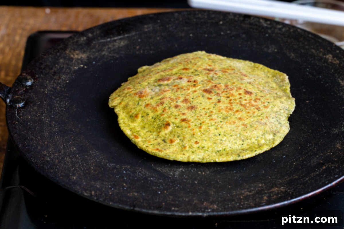 Aromatic Masala Paratha: Easy Yeast-Free Indian Flatbread 12 a freshy baked masala paratha on a black skillet
