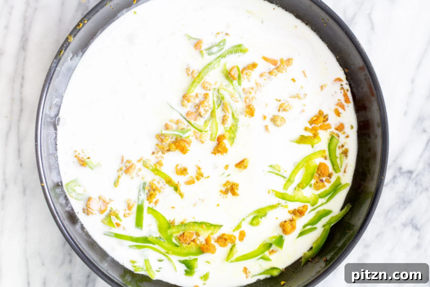 Vibrant Malaysian Tofu Curry 12 Coconut milk being added to spiced veggie mix in a black skillet