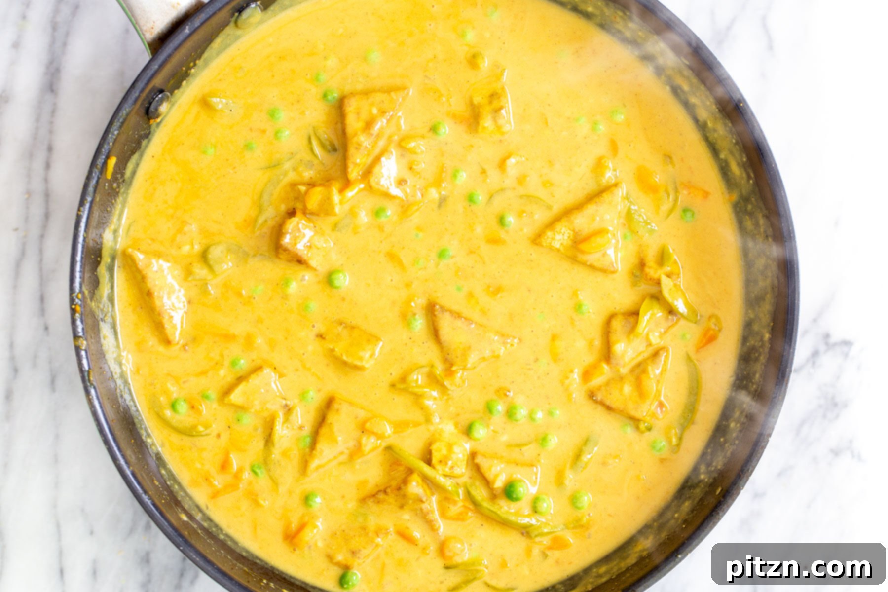 Vibrant Malaysian Tofu Curry 15 Creamy Malaysian tofu coconut curry in a sautéing pan
