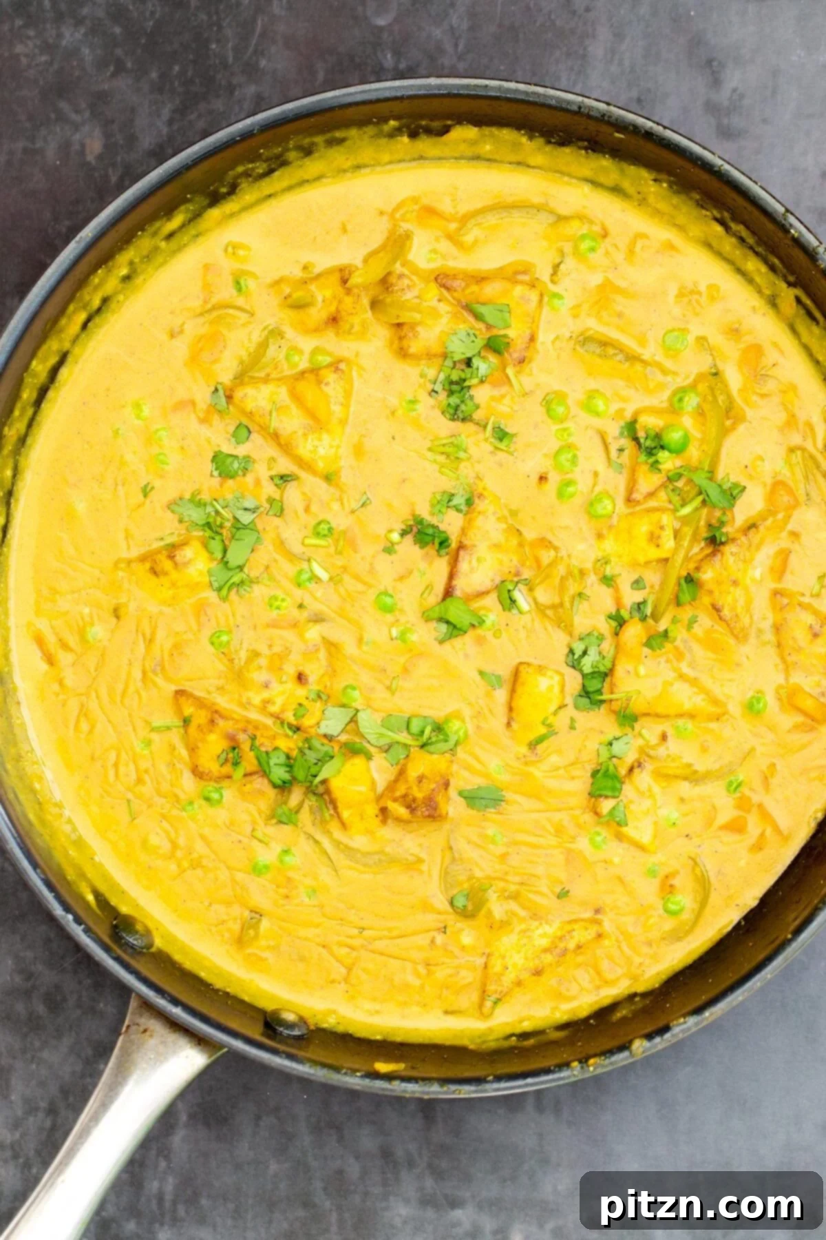 Vibrant Malaysian Tofu Curry 3 Creamy Malaysian tofu coconut milk curry in a black skillet sprinkled with cilantro
