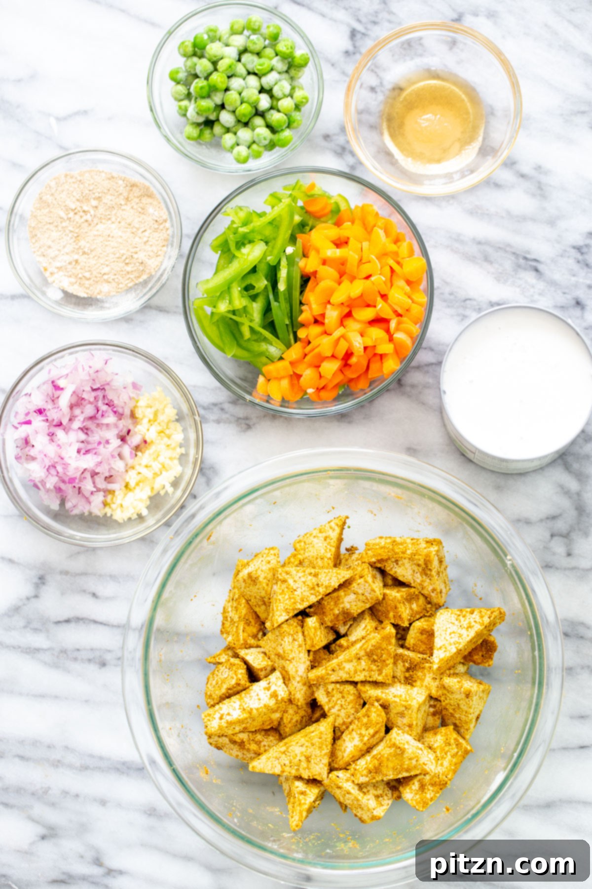Vibrant Malaysian Tofu Curry 7 Marinated tofu and several sides of veggies on a marble countertop
