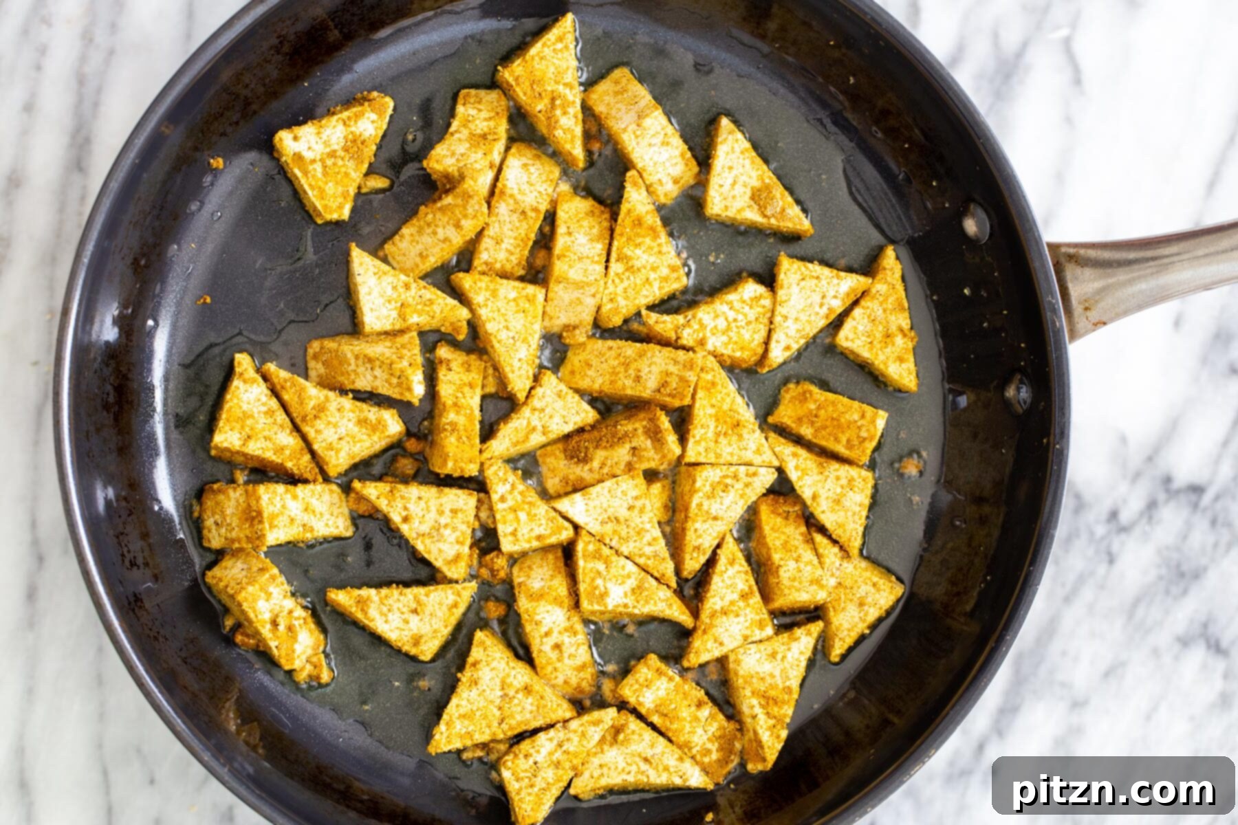 Vibrant Malaysian Tofu Curry 8 Marinated tofu frying in a black sautéing pan