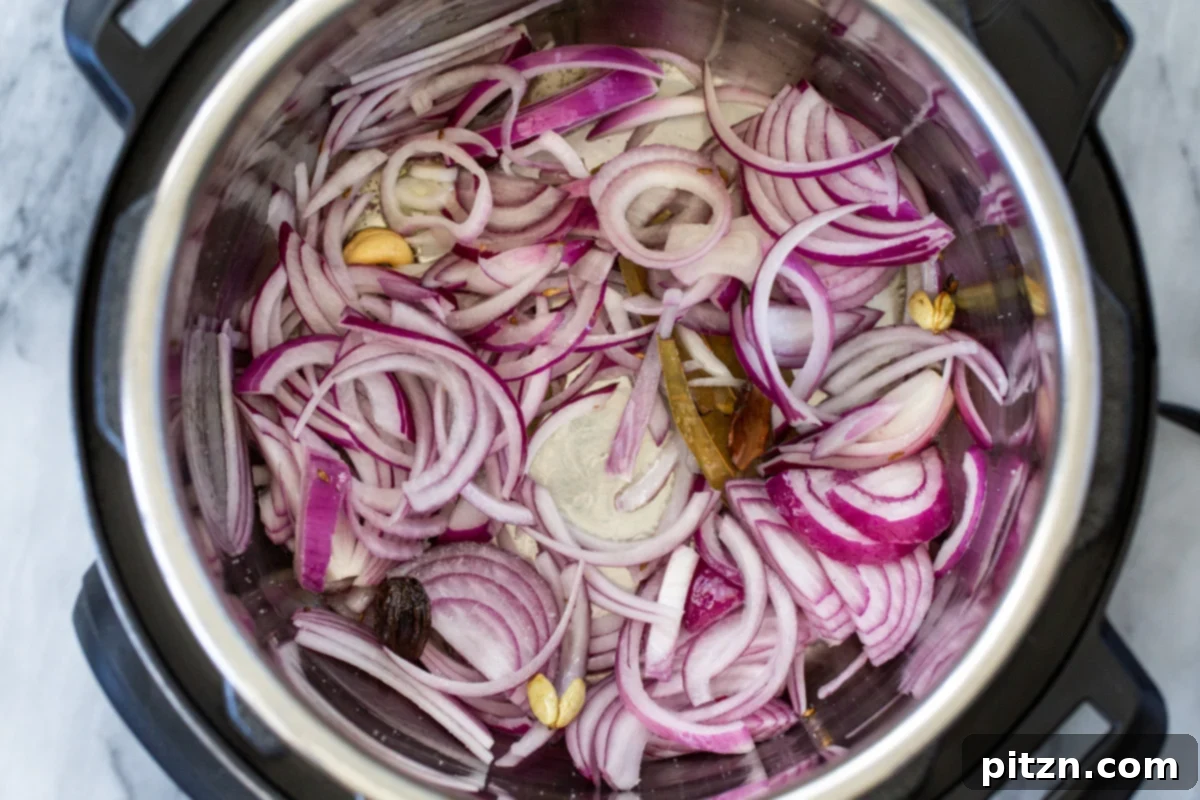 Fragrant Mushroom Biryani 11 A mix of onions and spices being sautéed in an Instant Pot, forming a fragrant base for the biryani.