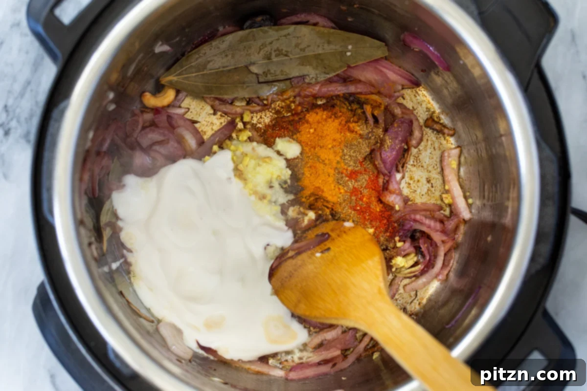 Fragrant Mushroom Biryani 13 Ground spices and creamy non-dairy yogurt being stirred into sautéed onions in an Instant Pot, forming a rich gravy base.