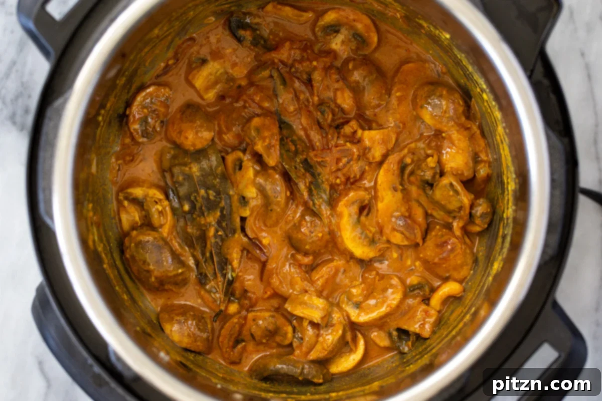 Fragrant Mushroom Biryani 16 Mushrooms simmering in a fragrant Indian gravy inside an Instant Pot, absorbing the rich flavors.