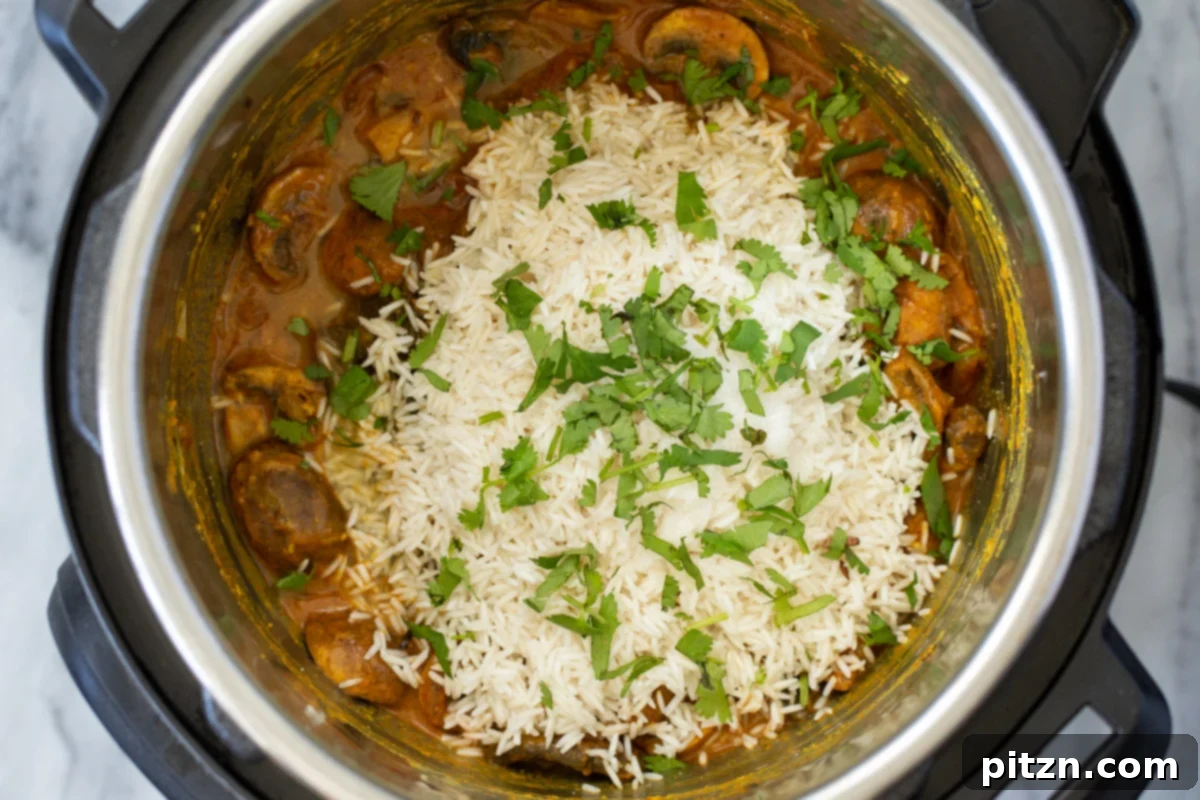 Fragrant Mushroom Biryani 18 A fragrant layer of chopped cilantro and mint topping drained soaked rice and a mushroom base in an Instant Pot.