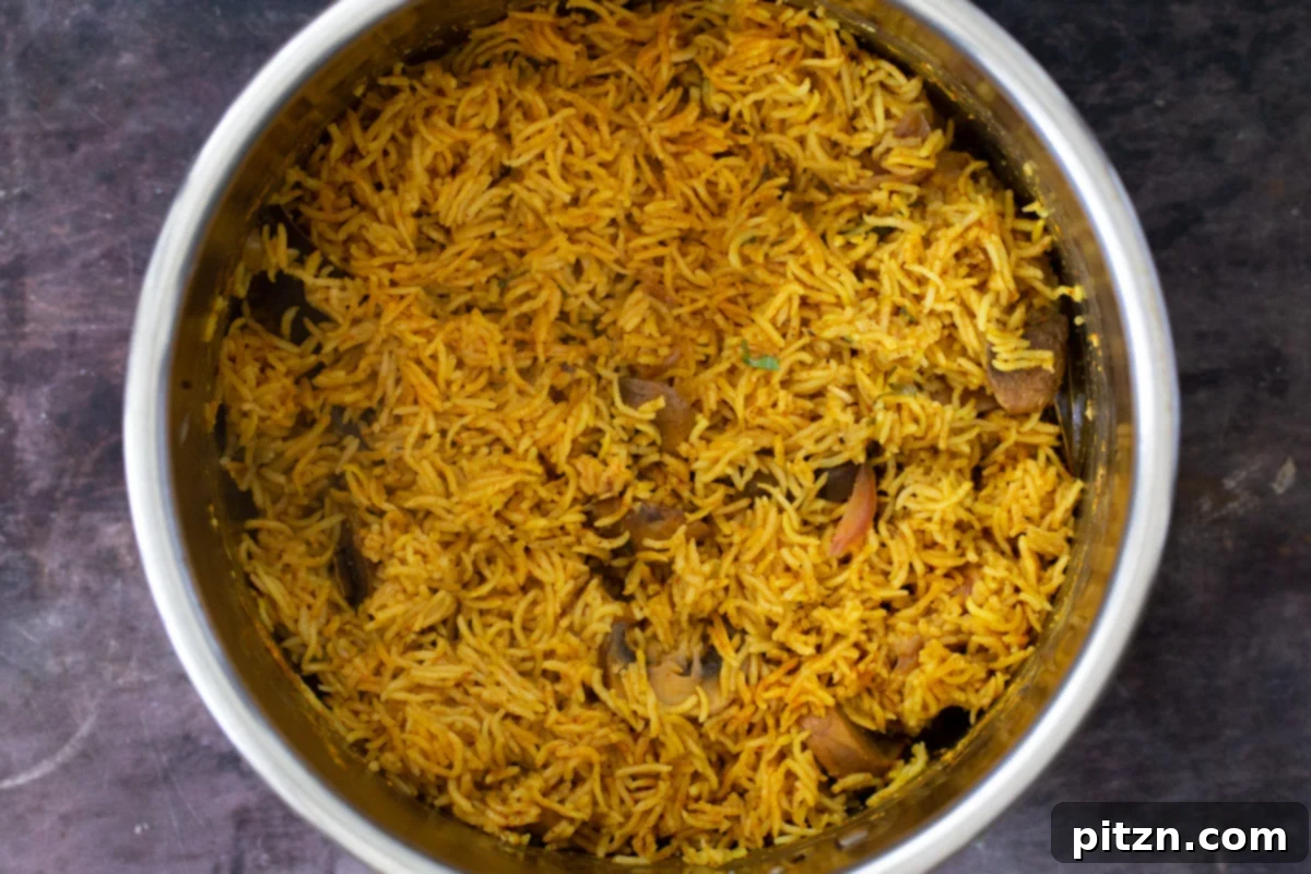 Fragrant Mushroom Biryani 22 A glorious Instant Pot filled with freshly cooked mushroom biryani, garnished with herbs.