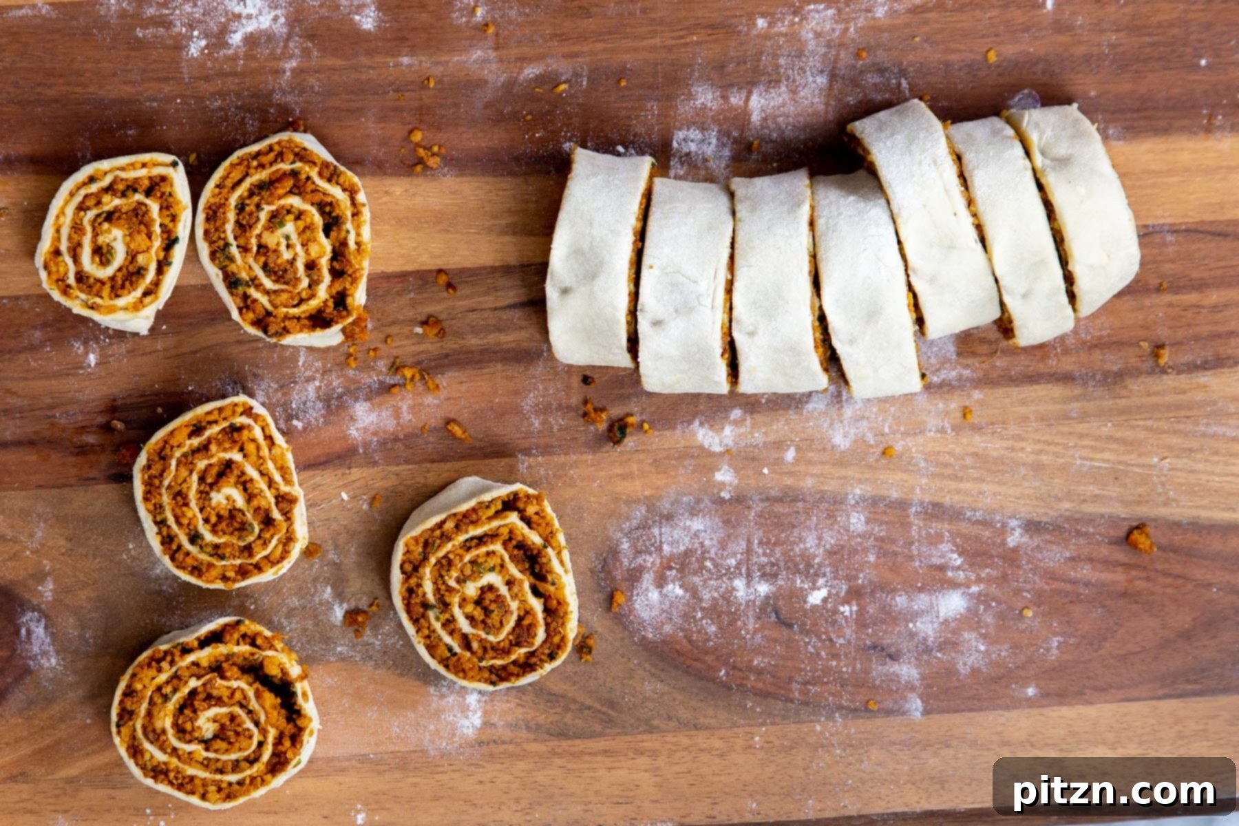 Freshly cut vegan pinwheels neatly arranged on a chopping board, showcasing their spiral design.