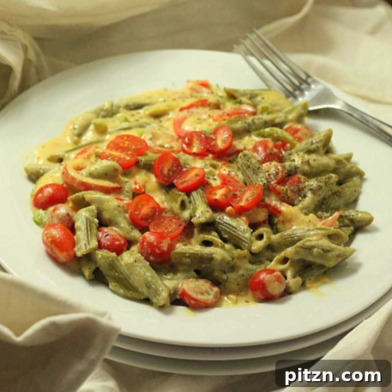 Spinach Penne Pasta in a rich sauce, garnished with fresh cherry tomatoes