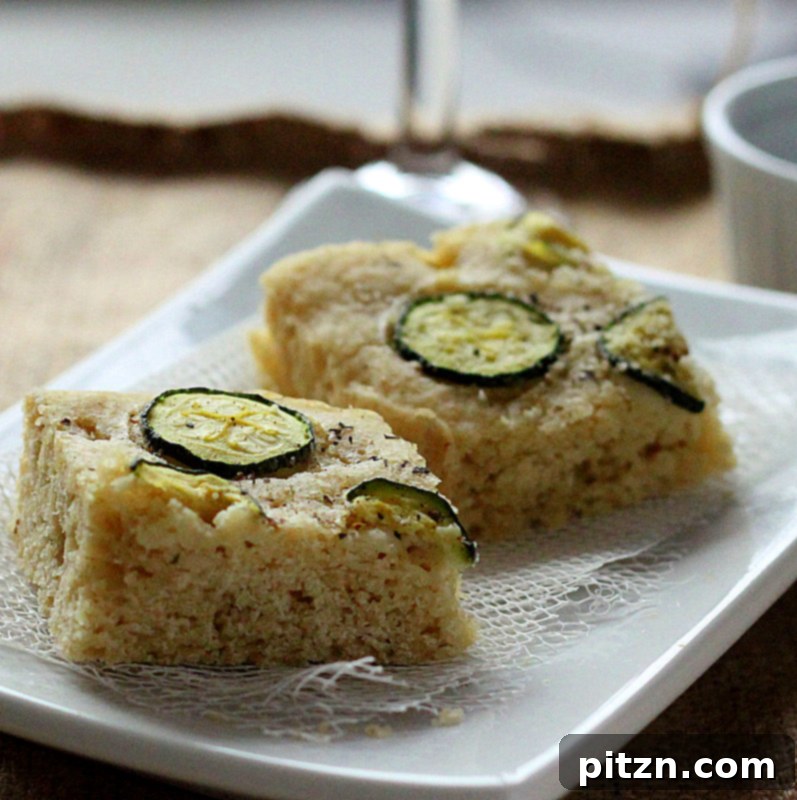 Naturally Gum-Free Vegan Gluten-Free Zucchini Basil Focaccia 5 A close-up of a slice of Gluten-free Zucchini Basil Focaccia, showing the soft, airy crumb and golden crust.