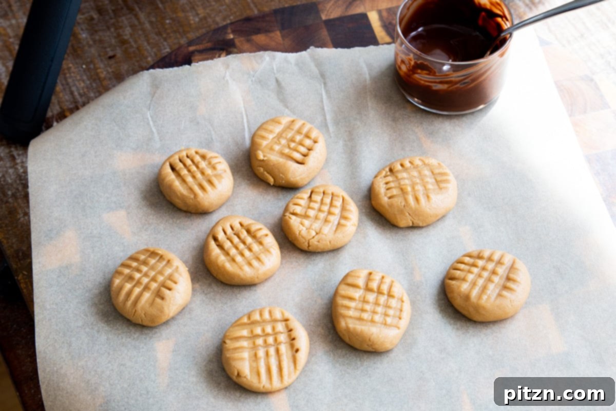 A selection of no-bake peanut butter cookies arranged alongside a small bowl of perfectly melted chocolate, ready for dipping.