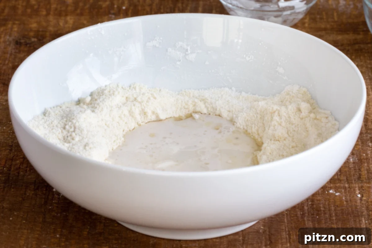 Spinach and Mushroom Stuffed Almond Flour Naan 10 Wet ingredients being added to dry ingredients in a white bowl for naan batter