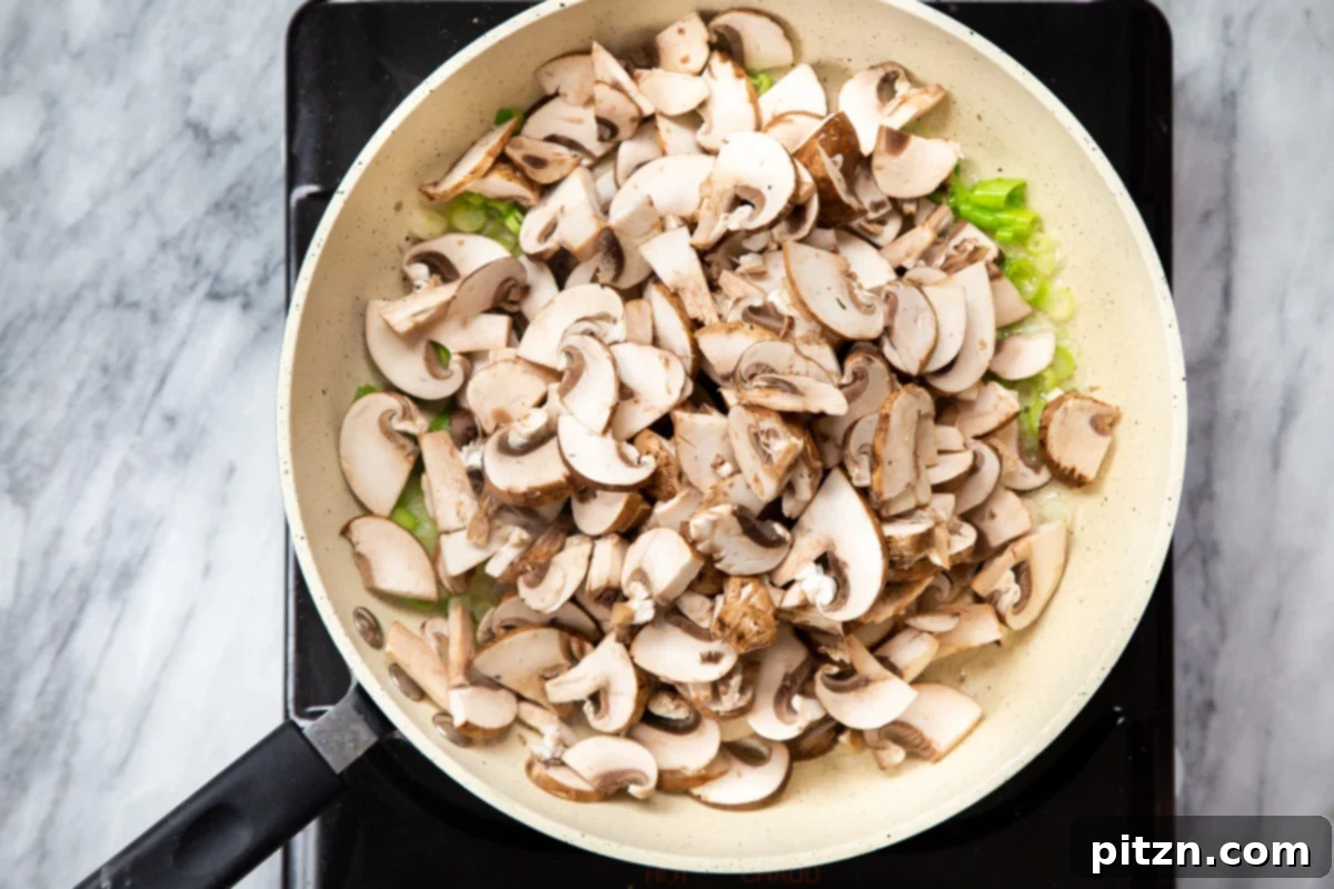 Spinach and Mushroom Stuffed Almond Flour Naan 14 Mushrooms and green onions sautéing in a pan, turning golden brown