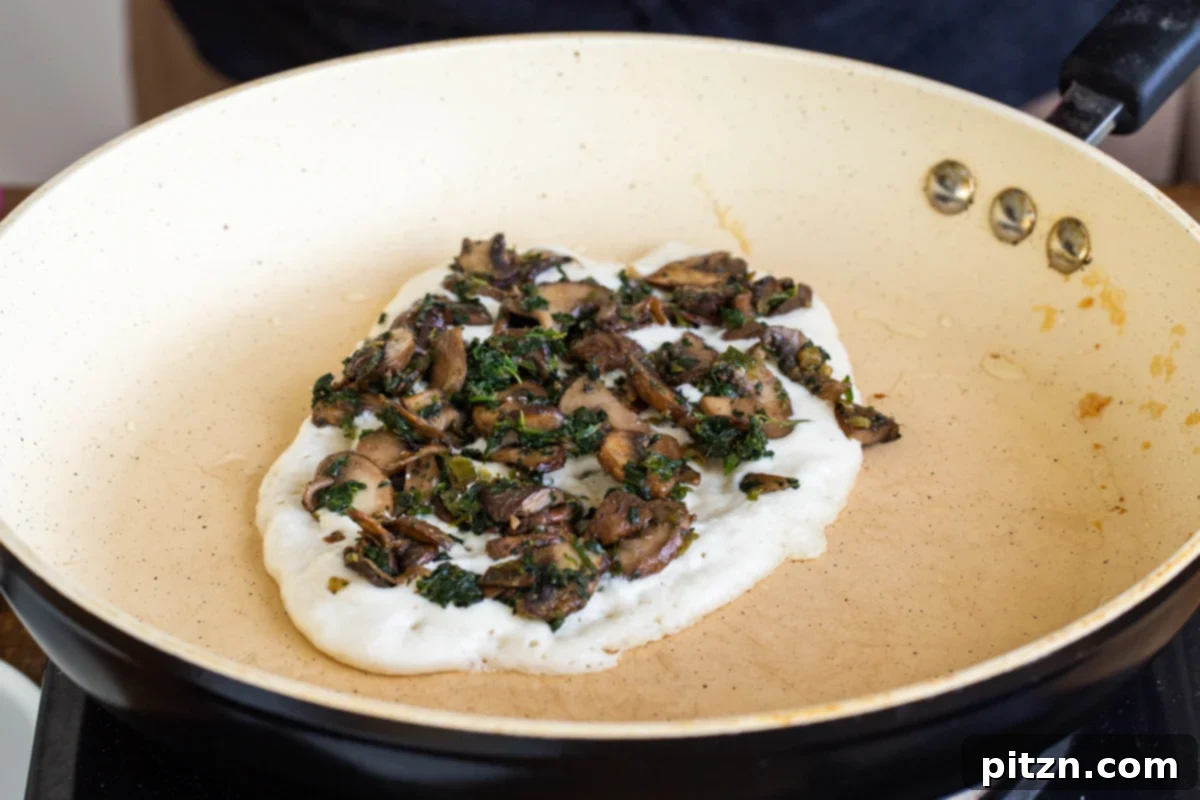 Spinach and Mushroom Stuffed Almond Flour Naan 17 Almond flour naan batter in a pan topped with mushrooms and spinach filling