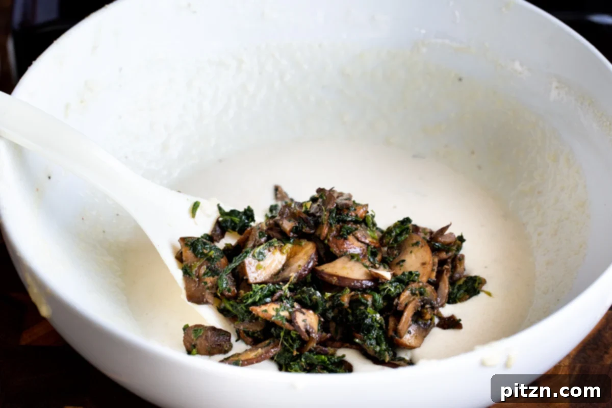 Spinach and Mushroom Stuffed Almond Flour Naan 21 Spinach mushroom mix being added to vegan naan batter in a bowl