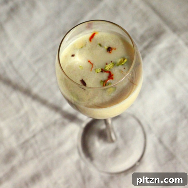 Two glasses of Thandai, one a spiced almond milk and the other a yogurt drink (Lassi), ready to be served.