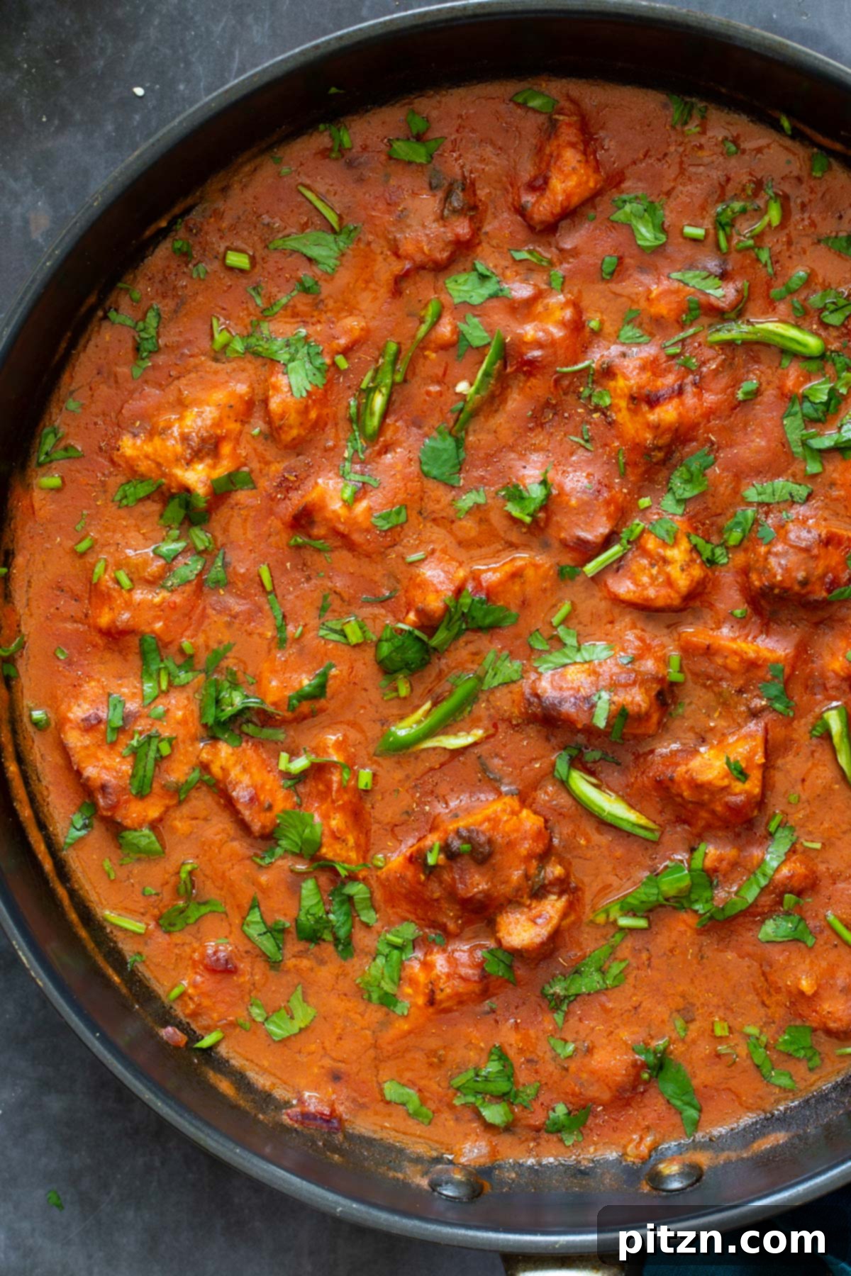 Plant-Based Chicken Changezi 3 Close-up of Vegan Chicken Changezi in a black skillet, showcasing the rich tomato-coconut gravy and tofu chunks.