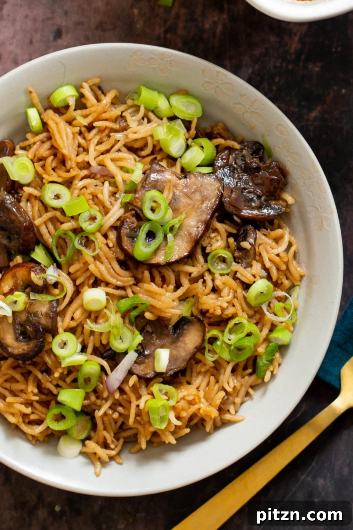 A serving of fluffy baked vegan mushroom rice sprinkled with fresh green onion, ready to be enjoyed.