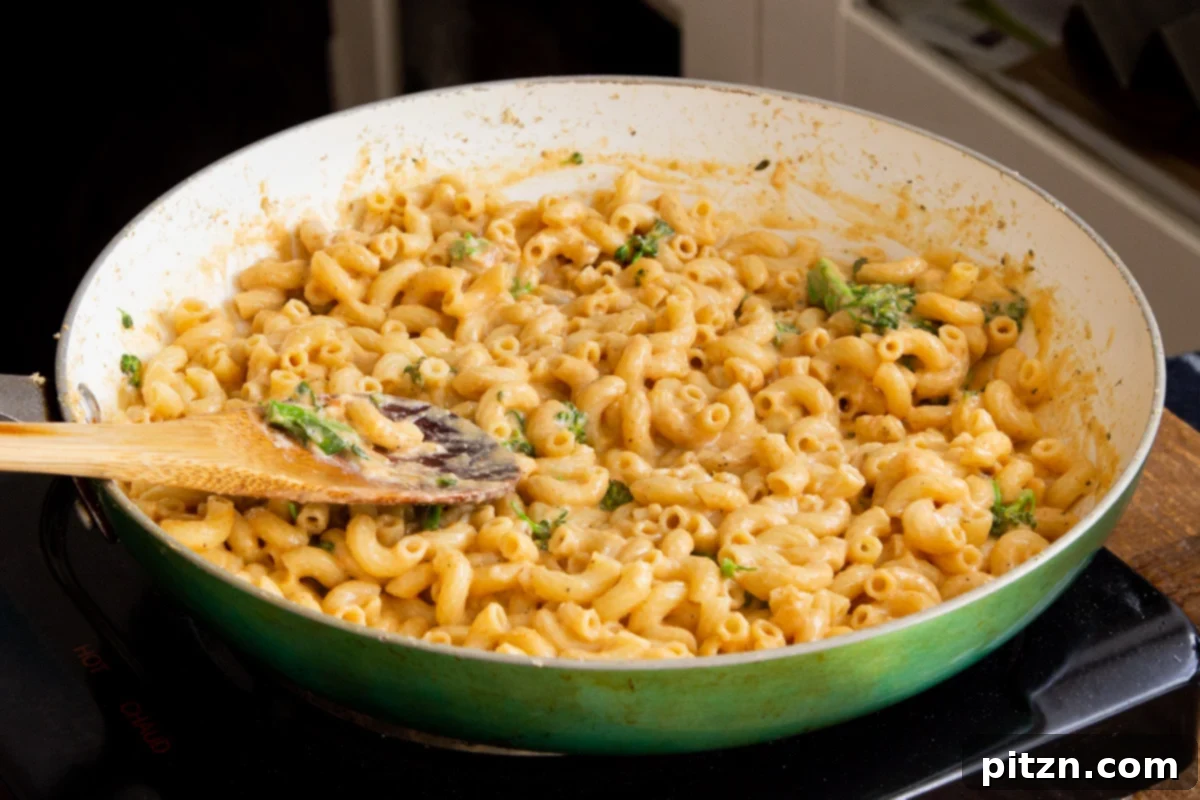 Fiery Vegan Skillet Mac and Cheese 12 Delicious vegan skillet mac and cheese in a skillet, generously mixed with tender green broccoli florets, enhancing its nutritional value and visual appeal.