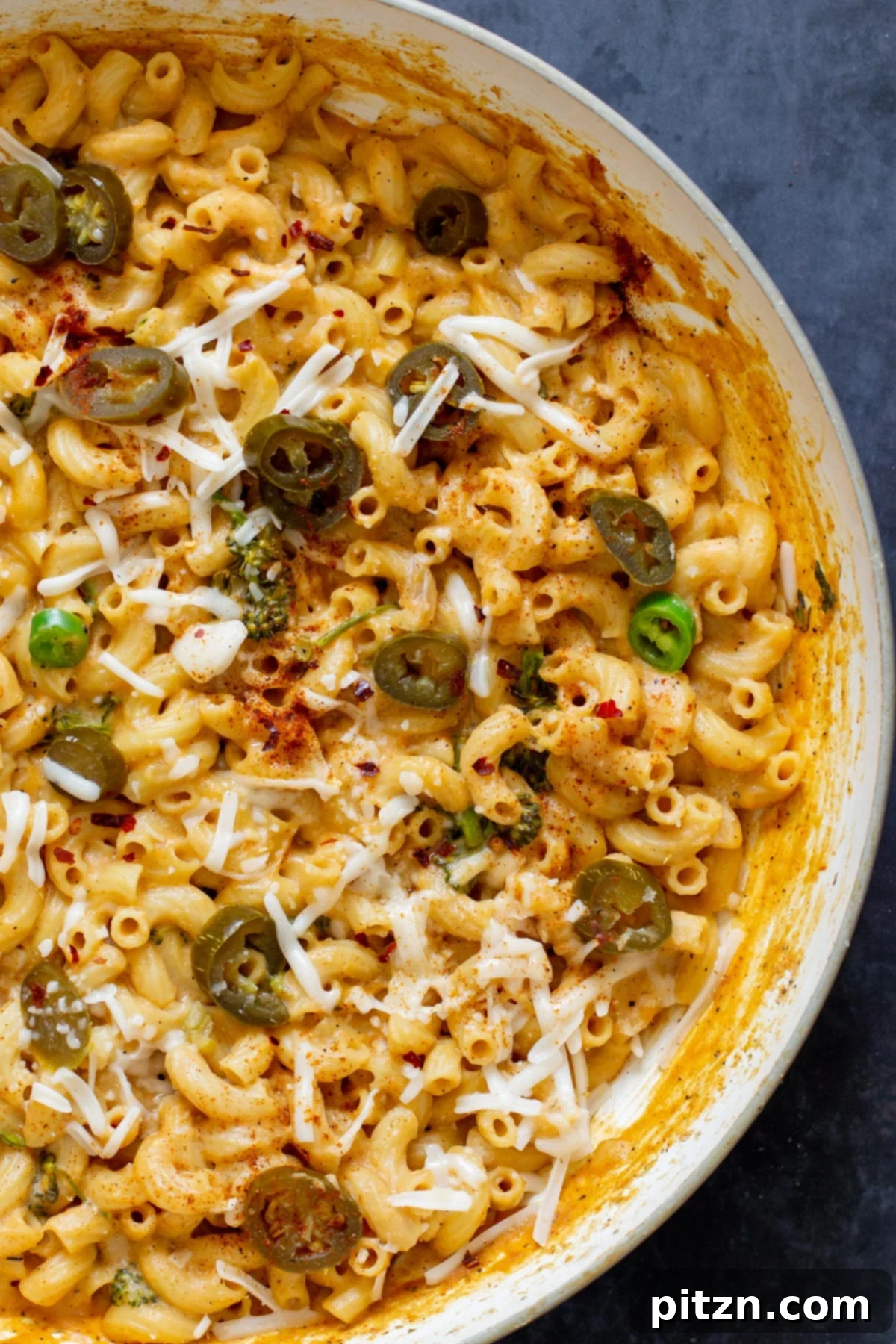 Fiery Vegan Skillet Mac and Cheese 5 An inviting overhead shot showcasing a vibrant green skillet brimming with creamy vegan jalapeño mac and cheese, ready to be served.