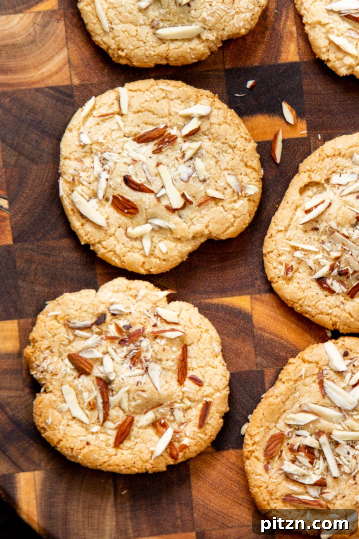 Irresistible Vegan Gluten-Free Almond Coconut Joy Cookies 2 Crisp vegan gluten-free Almond Joy cookies on a wooden board, with hidden chocolate and almond slivers, perfect for holidays
