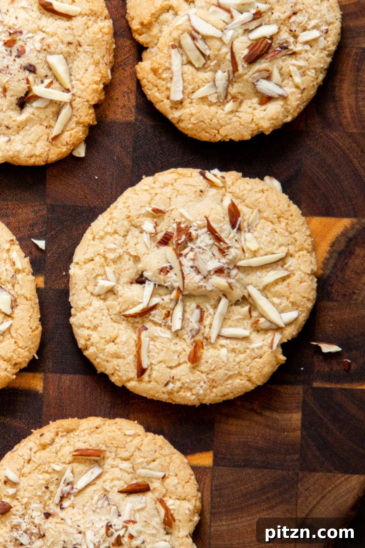Irresistible Vegan Gluten-Free Almond Coconut Joy Cookies 14 A stack of golden brown vegan gluten-free Almond Joy cookies on a rustic wooden chopping board