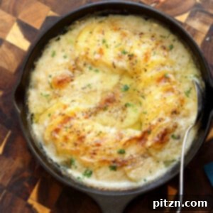 Creamy Vegan Scalloped Potatoes in a cast iron skillet, presented on a rustic wood board.