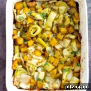 A vibrant casserole dish filled with beautifully roasted golden beets, leeks, and fennel, creating a delicious medley of root vegetables.