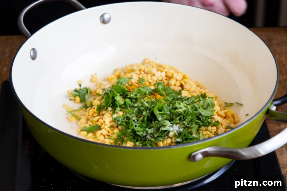 Chataka Dal: Spicy Maharashtrian Toor Dal 7 Washed lentils and fresh cilantro combined in a saucepan with water, before simmering, showcasing the initial steps of preparing Chataka Dal.
