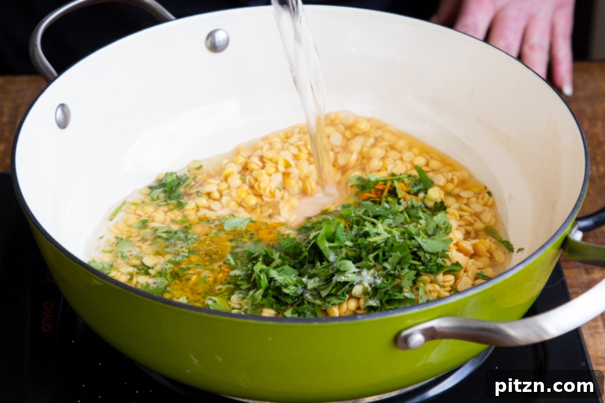 Chataka Dal: Spicy Maharashtrian Toor Dal 8 Clear water being poured into a saucepan with softened lentils and fresh cilantro, perfectly prepared for cooking the Chataka Dal.