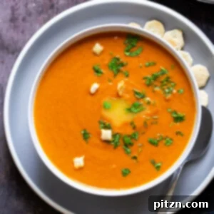 Velvet Roasted Tomato Bliss 6 A square image depicting a bowl of vegan roasted tomato soup, garnished and inviting.