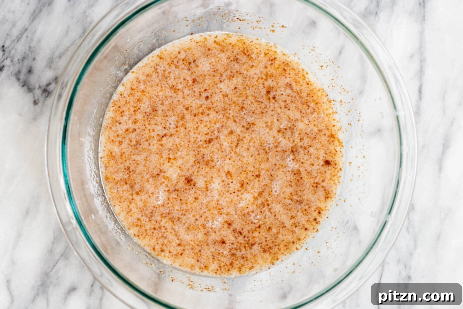 Plant-Based Boston Dream Cake 9 Fully mixed liquid ingredients for vegan Boston Cream Pie cake, appearing smooth and pale in a glass bowl.